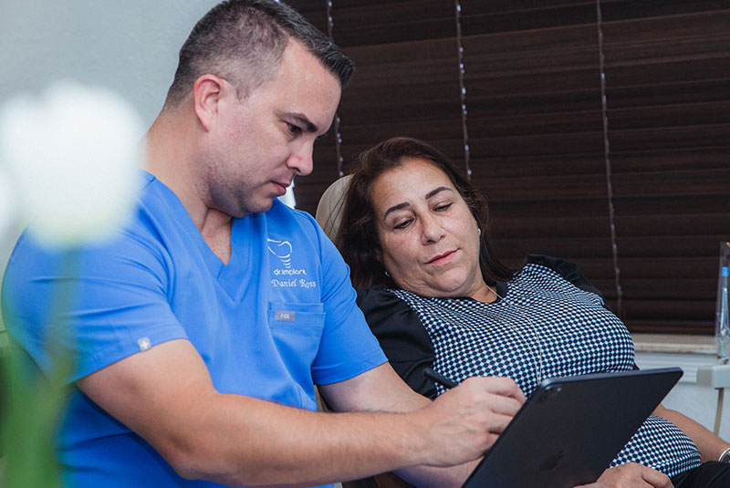 doctor showing patient display images for dental procedure